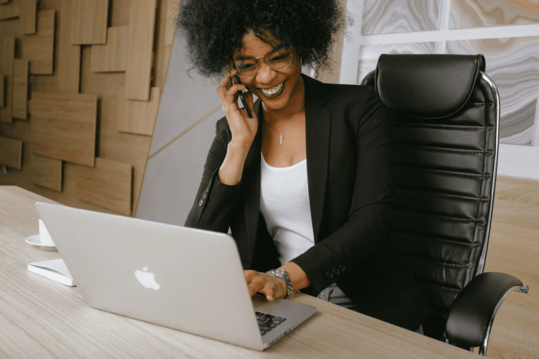 Girl working on Laptop while talking on the phone.