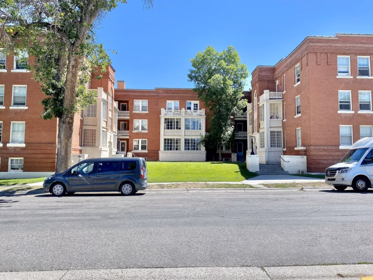 Brick apartment building on a tree-lined street in Bozeman, Montana